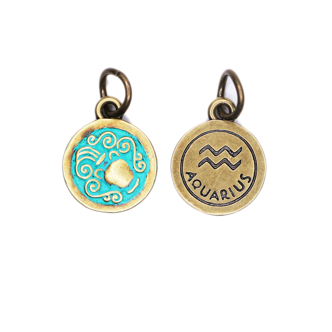 Brass-tone Aquarius zodiac charm painted turquoise. One side depicts an urn overflowing with water. Reverse side shows the water sign and says "AQUARIUS".