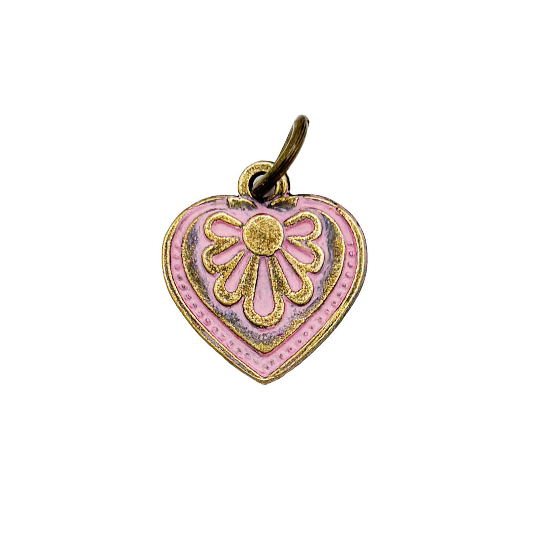 Antique bronze charm painted pink and burnished to shiny gold. Graphic details mimic a blooming flower. Comes with attached jump ring.