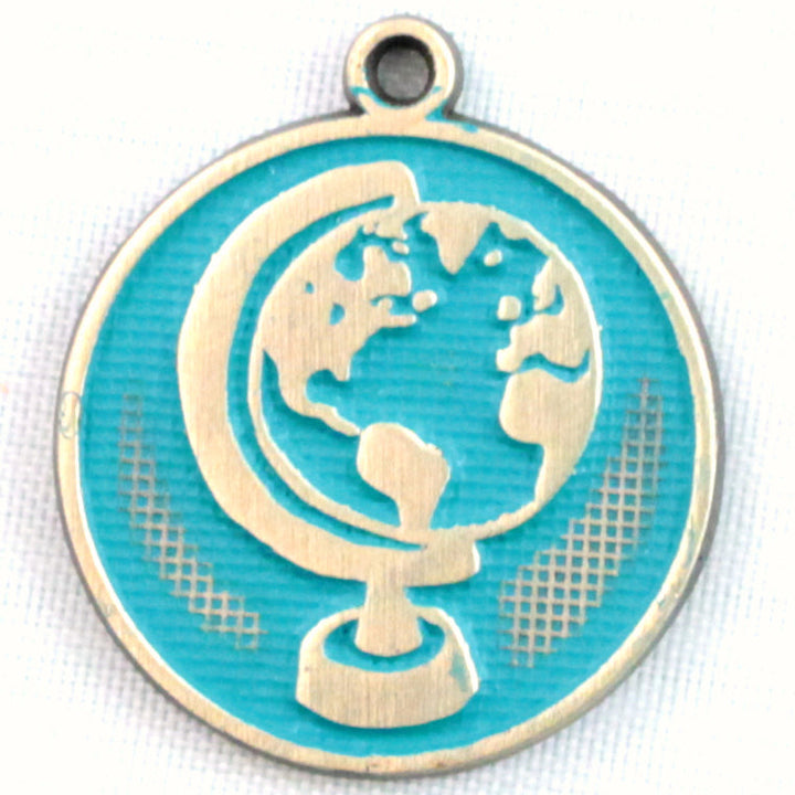 Antique bronze charm painted aqua and burnished to shiny gold. One side depicts a globe on it's axis. Reverse side says "Be the change you want to see".