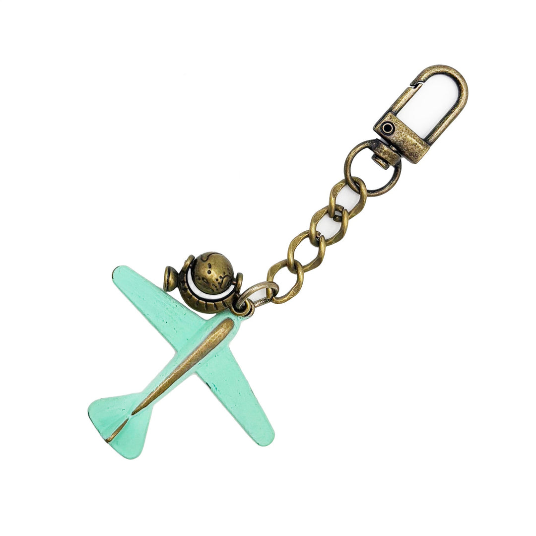 Large antique bronze airplane charm painted mint green with an antique gold rotating globe charm. On a short chain with modern clasp to wear on your purse/handbag. Total length of this bag charm is 4 1/2".