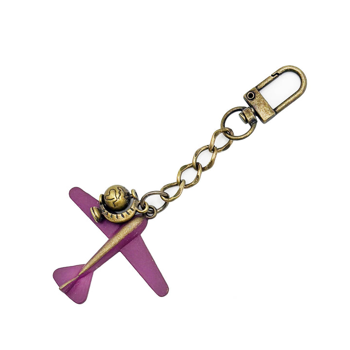 Large antique bronze airplane charm painted mauve with an antique gold rotating globe charm. On a short chain with modern clasp to wear on your purse/handbag. Total length of this bag charm is 4 1/2".