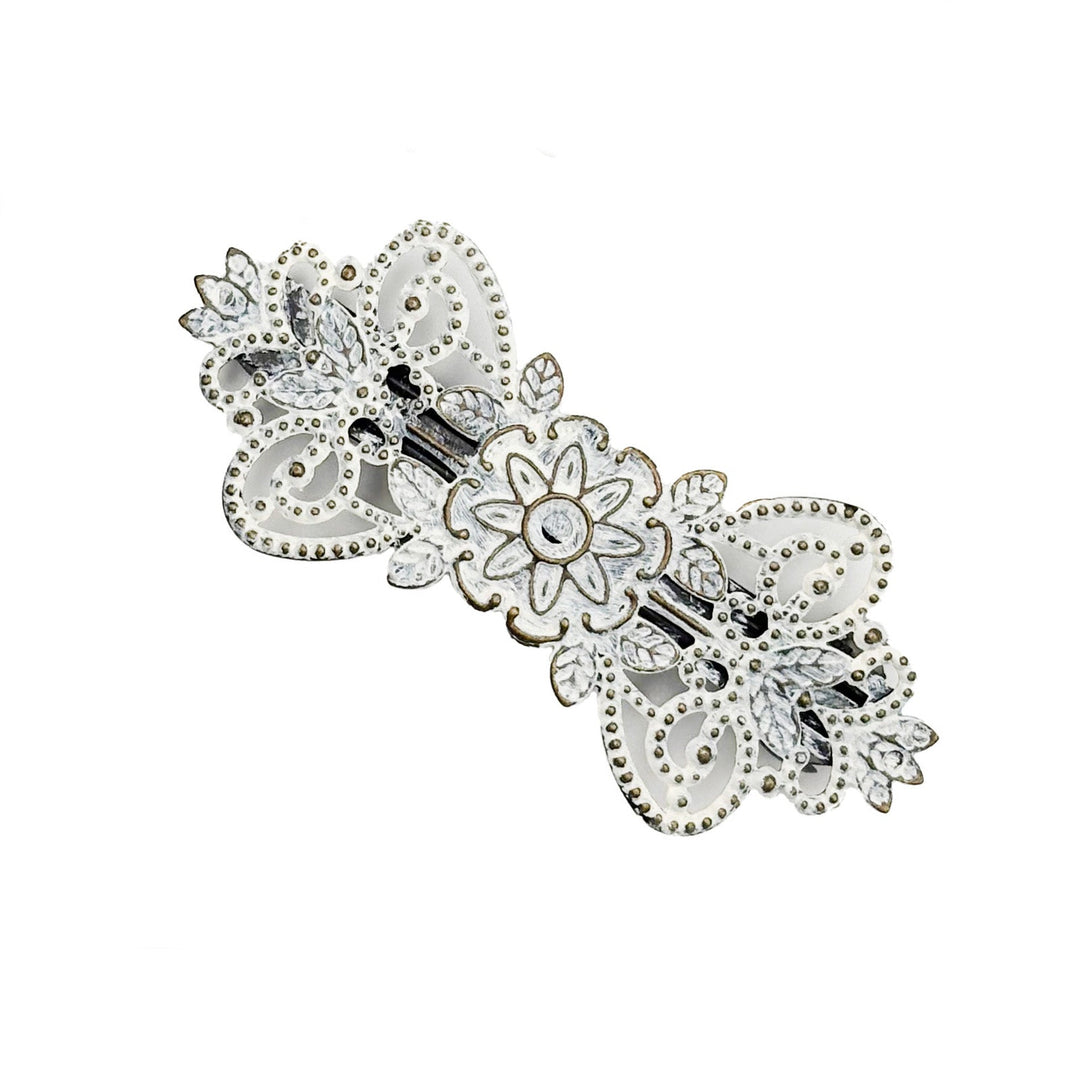 Antique bronze filigree barrette with a flower, vines and leaves. Hand-painted white and burnished to shiny gold.