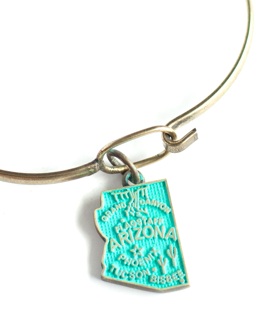 Antique bronze Alaska state charm painted turquoise and burnished to shiny gold. Map depicts location of Nome, Juneau and Fairbanks and shows a large deer stag.