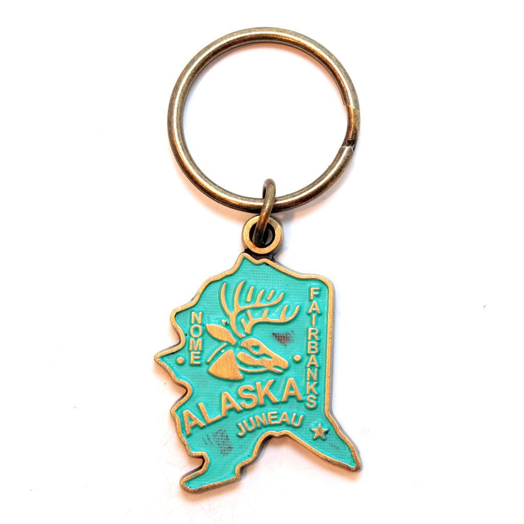 Antique bronze 1 5/8" charm keychain on 1 1/4" keyring. Alaska state charm painted turquoise and burnished to shiny gold. Map depicts location of Nome, Juneau and Fairbanks and shows a large deer stag.