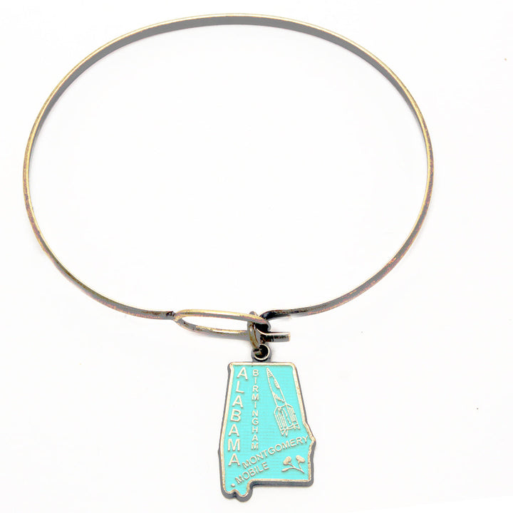 Antique bronze Alabama state charm painted turquoise and burnished to shiny gold. Map depicts location of Birmingham, Montgomery and Mobile and shows a rocket ship.