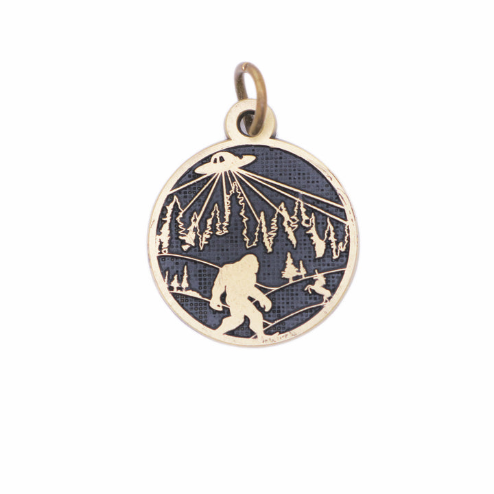 Whimsical charm with illustration of bigfoot, a UFO and a unicorn. The reverse says "Believe in Yourself." Antique bronze painted black and burnished.