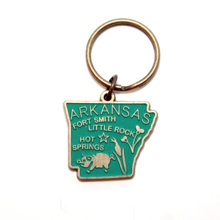 Antique bronze 1 5/8" charm keychain on 1 1/4" keyring. Hand-painted teal. Map depicts location of Fort Smith, Little Rock and Hot Springs. It has agricultural illustrations like a pig and corn.