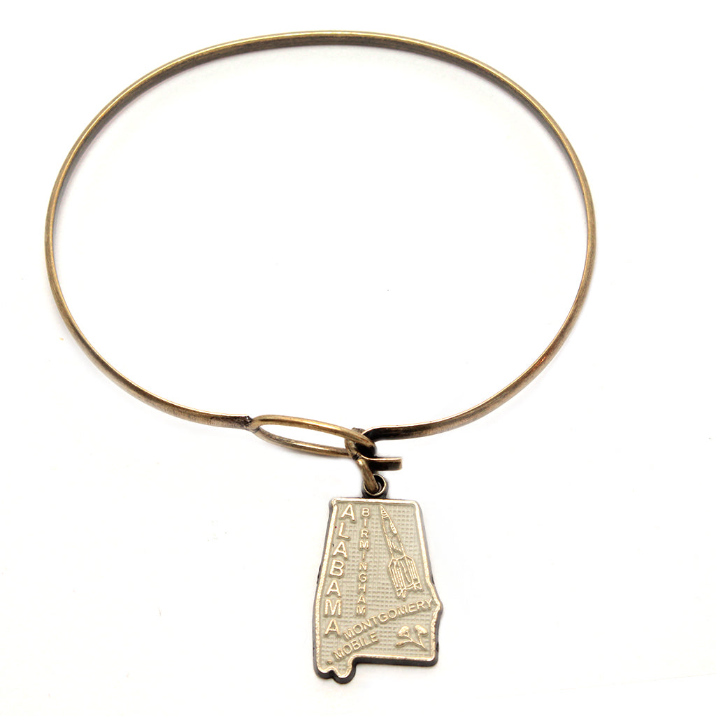 Antique bronze alabama state charm painted cream and burnished to shiny gold. Map depicts location of Birmingham, Montgomery and Mobile and shows a rocket ship.