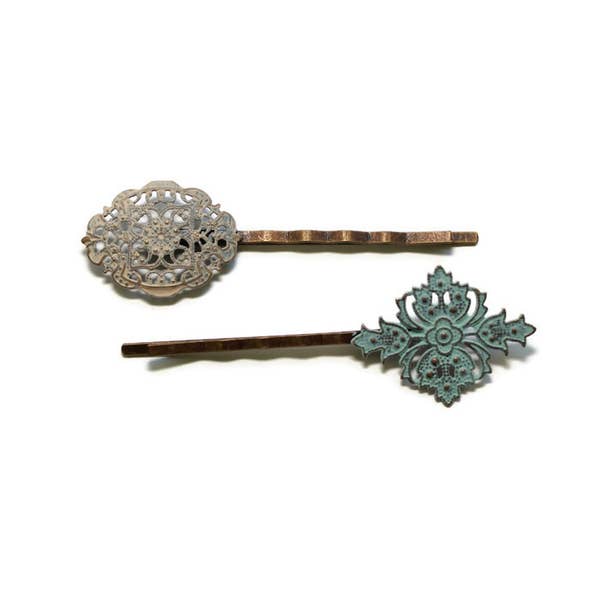 Mismatched filigree charms on bobby pins. Hand-painted sage green and beige. Intricate Victorian flourishes for vintage bobby pin appeal.