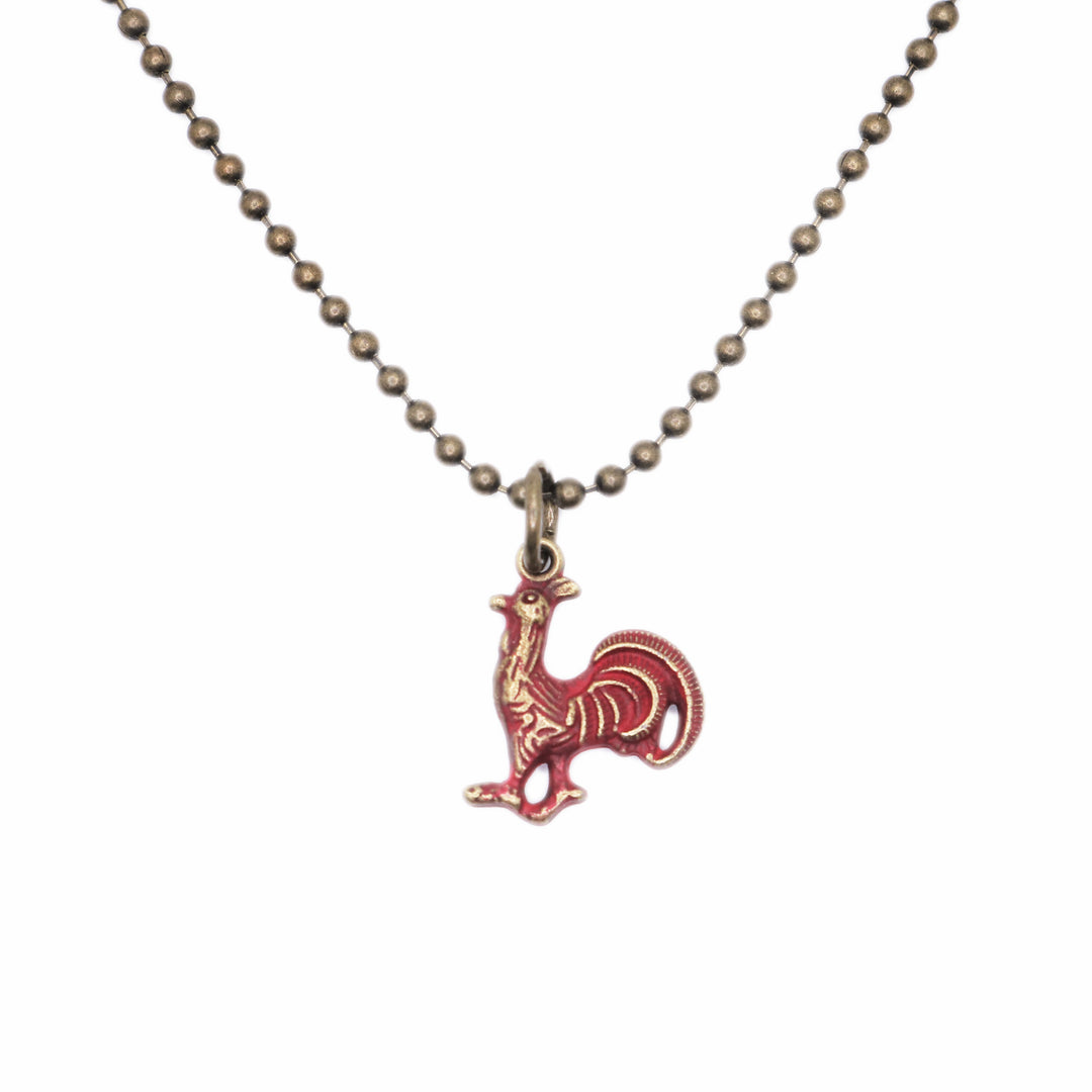 Rooster Charm with farmgirl flair, hand-painted by artisans in Denver, CO. Charm is 5/8” long, available as a card, bracelet, or necklace. Hypoallergenic, lead-free, and nickel-free.
