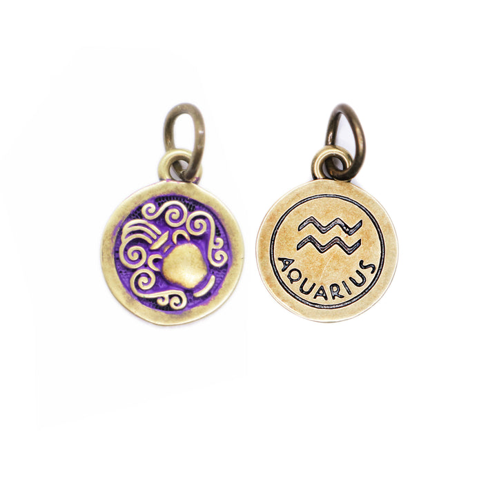 Brass-tone Aquarius zodiac charm painted purple. One side depicts an urn overflowing with water. Reverse side shows the water sign and says "AQUARIUS".