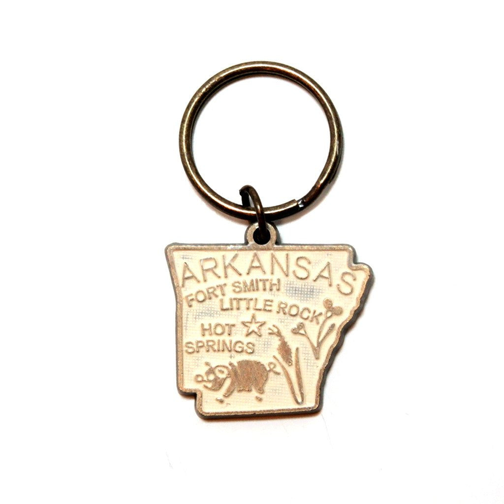 Antique bronze 1 5/8" charm keychain on 1 1/4" keyring. Hand-painted cream. Map depicts location of Fort Smith, Little Rock and Hot Springs. It has agricultural illustrations like a pig and corn.