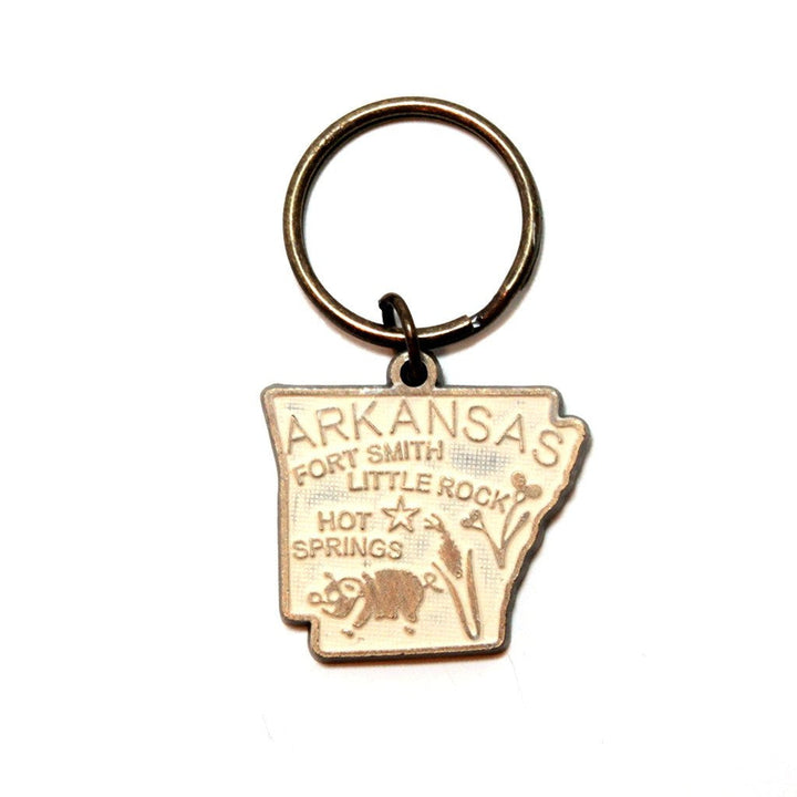 Antique bronze 1 5/8" charm keychain on 1 1/4" keyring. Hand-painted cream. Map depicts location of Fort Smith, Little Rock and Hot Springs. It has agricultural illustrations like a pig and corn.